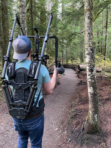 Camera operator testing the Ready Rig and stabilized 180° camera on a forest trail