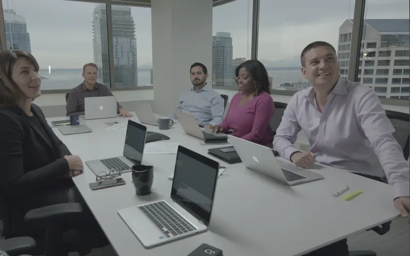 Corporate team around a conference table on a video shoot
